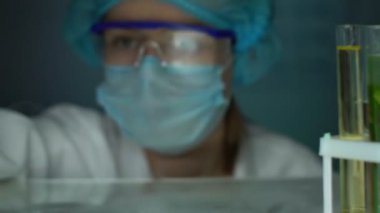 Laboratuar işçisi sarı sıvı, kozmetoloji ile test tüpünde yağlı madde damlama