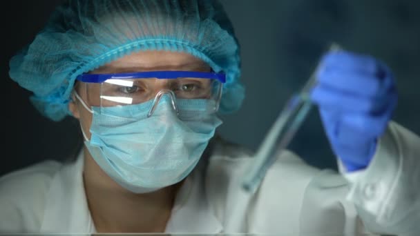 Исследователь, анализирующий реакцию в трубке с голубой прозрачной жидкостью, моющие средства — стоковое видео
