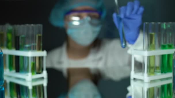 Químico que añade sustancia grasa en el tubo con líquido de ensayo azul, análisis de disolvente — Vídeos de Stock