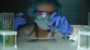 Laboratuar asistanı buzdolabında aşı alarak ve şırınga salgın salgını doldurma