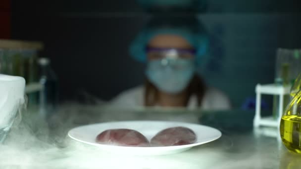 Lab assistant examining swine kidneys with magnifying glass, nutritional quality — Stock Video