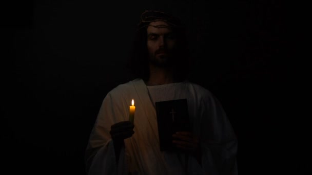 Santo en corona de espinas sosteniendo vela y santa biblia, fe cristiana en dios — Vídeos de Stock