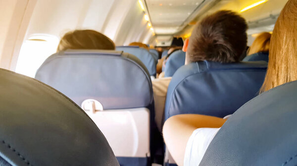 Tourists sitting in airplane cabin, flight conditions, transportation service
