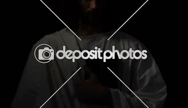 Beyaz Robe içinde Monk karanlık arka plan, Hıristiyanlık karşı kutsal İncil tutarak