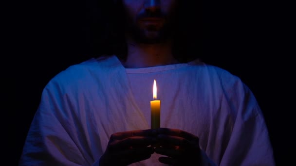 Paroquiano de roupão com vela acesa, rezando a Deus na escuridão, Cristianismo — Vídeo de Stock