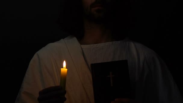 Jesus Cristo na coroa de espinhos segurando a Bíblia sagrada e queimando vela, profeta — Vídeo de Stock