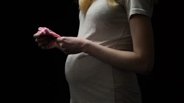 임신 한 여자 배, 어린 소녀, 아이를 기다리는에 분홍색 아기 양말 퍼 팅 — 비디오