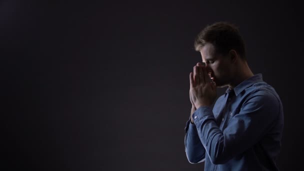 Joven varón orando, bendiciendo a Dios bajo la luz del cielo, signo del cristianismo — Vídeos de Stock