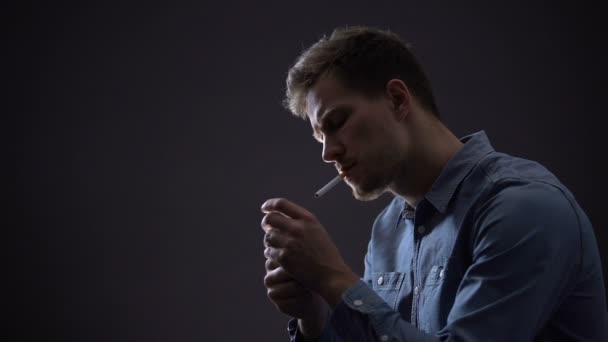 Depressed man smoking isolated on dark background, thinking about life problems — Stock Video