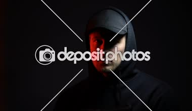 Karanlık arka plana karşı silahla erkek holigan, soygun için tehlike ceza hazır