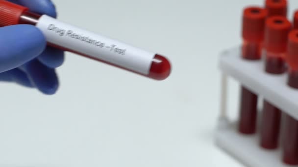Тест на резистентность к лекарствам, доктор держит образец крови в трубке крупным планом, здоровье — стоковое видео