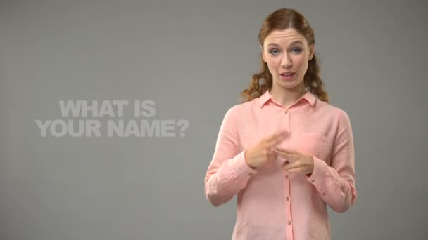 Lady vragen wat is je naam in asl, tekst op achtergrond, communicatie voor doven — Stockvideo