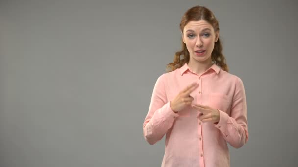 Mulher perguntando qual é o seu nome em linguagem gestual, mostrando palavras em uma lição — Vídeo de Stock