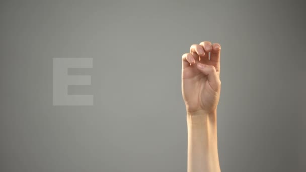Lettre E en langue des signes, main sur l'arrière-plan, communication pour sourds, leçon — Video