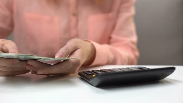 Female accountant counting dollar banknotes, housewife planning family budget — Stock Video