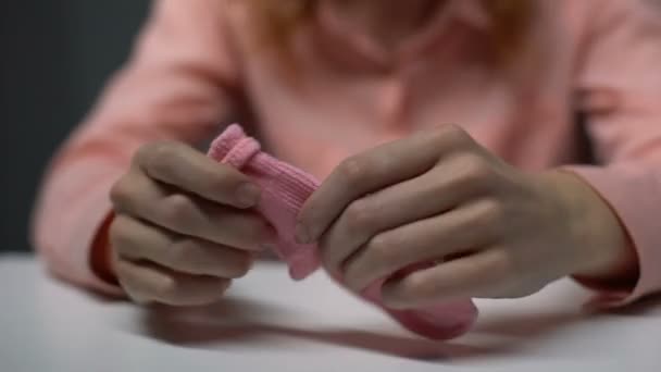 Депрессивная юная леди трёт розовый детский носок и плачет от отчаяния, бесплодия — стоковое видео