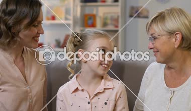 Anne ve büyükanne öpüşme kız, yeni sevgi dolu aile kucaklayan mutlu bir çocuk evlat edinmek