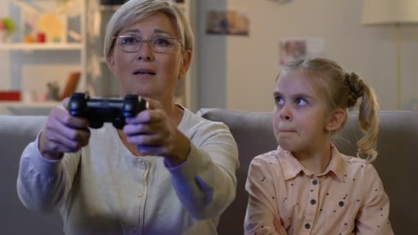 Grandmother ignoring child while playing video game with console, addiction — Stock Video