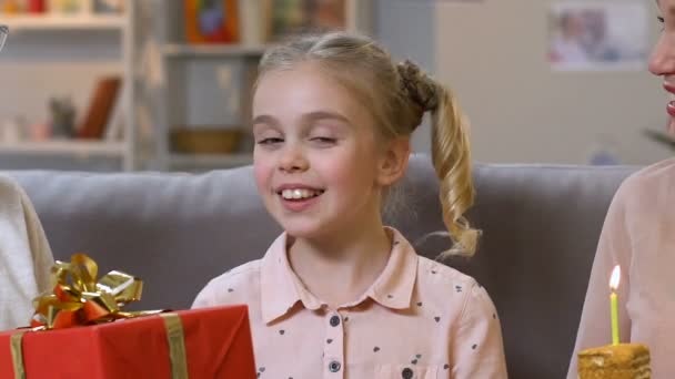 興奮した女の子が家族と祝うために非常に幸せな誕生日の蝋燭を吹く — ストック動画