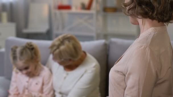 Мама задоволена старою нянею, яка дивиться після маленької доньки, служба допомоги дітям — стокове відео