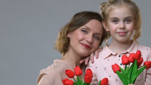 Retrato de mãe e filha segurando tulipas, feminilidade e humor primavera — Vídeo de Stock