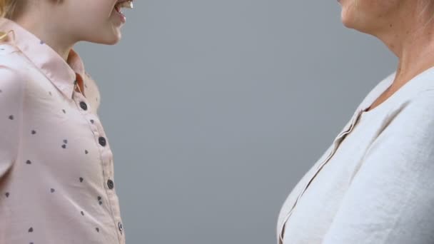 Söt flicka ger tulpaner till mormor, kramas och gratulera henne på årsdagen — Stockvideo