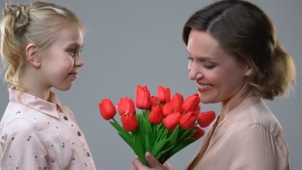 Menina bonito dando flores para a mãe amada, surpresa para o aniversário ou 8 de março — Vídeo de Stock