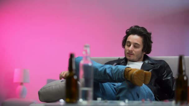 Pijany facet chłodzenie na kanapie na imprezie, konfetti, spada w dół, relaks szczęśliwy — Wideo stockowe