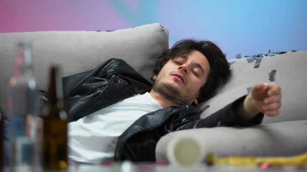 Pemuda mabuk tidur di sofa setelah pesta panjang malam, menganggur hidup, mabuk — Stok Video