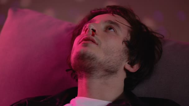 Чоловіча кокаїнова залежність з кривавим носом, що оглядається в нічному клубі, галюцинація — стокове відео