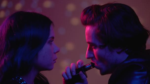 Homem exalando fumaça de cigarro eletrônico na boca das mulheres, seduzindo por uma noite de sexo — Vídeo de Stock