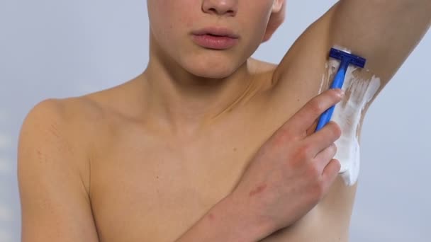 Depilación masculina, persona afeitándose la axila, utilizando una maquinilla de afeitar para eliminar el cabello, primer plano — Vídeos de Stock