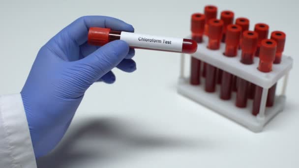 การทดสอบคลอโรฟอร์ม หมอแสดงตัวอย่างเลือดในท่อ การวิจัยในห้องทดลอง การตรวจสุขภาพ — วีดีโอสต็อก