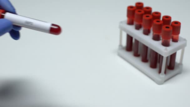 Test G6PD, medico che mostra il campione di sangue in tubo, ricerca di laboratorio, controllo dello stato di salute — Video Stock