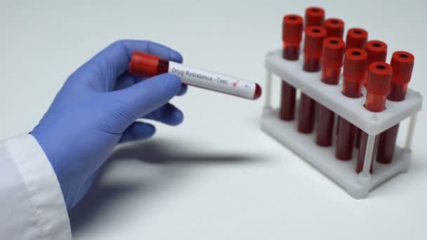 Отрицательный тест на лекарственную устойчивость, доктор показывает образец крови в трубке, лабораторные исследования — стоковое видео
