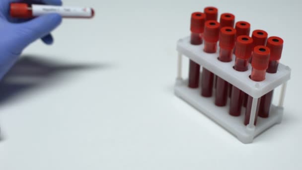 Prueba de hepatitis C positiva, médico mostrando muestra de sangre en tubo, chequeo de salud — Vídeo de stock