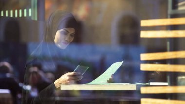Ortak telefonda sohbet kafede, çalışma güzel Müslüman Bayan serbest meslek
