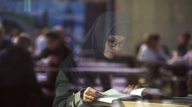 Genç Arapça Bayan okuma kitabı kafe, öğrenci sınavlara, edebiyat hazırlanıyor