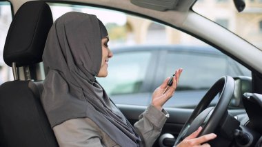 Araba anahtarları tutan hijab yeni otomatik satınalma, neşeli kadın sürücü belgesi