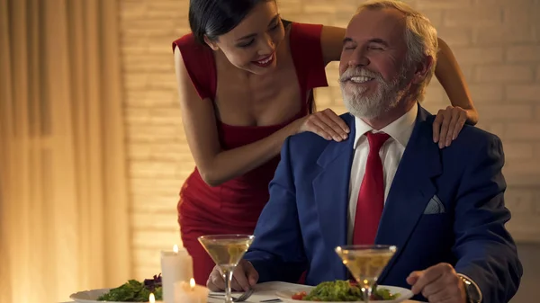 Beautiful Young Lady Massaging Shoulders Old Rich Man Flirting Date — Stock Photo, Image