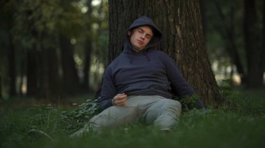 Savunmasız alkolik Park, ağaç altında uyku dikkatsiz ve çılgın gençlik