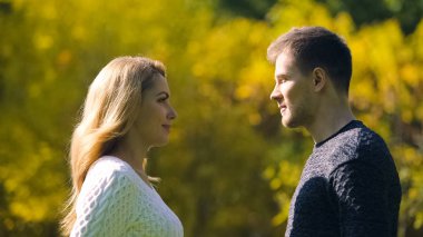 Çift flört ve birbirine bakarak sonbahar ormanda birlikte sonsuza kadar