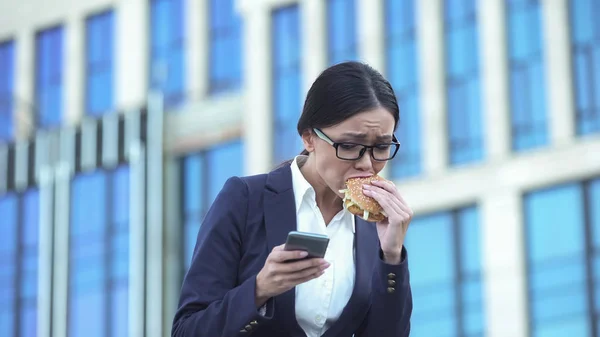 Upptagen Affärskvinna Skicka Post Smartphone Bita Burger Lunchrast — Stockfoto