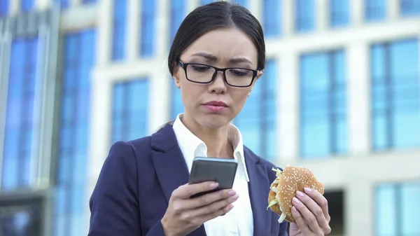 Lavoro Femminile Dipendente Lettura Business News Holding Hamburger Ora Pranzo — Foto Stock