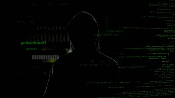 Male hacker in black viewing confidential information, cyber crime problem