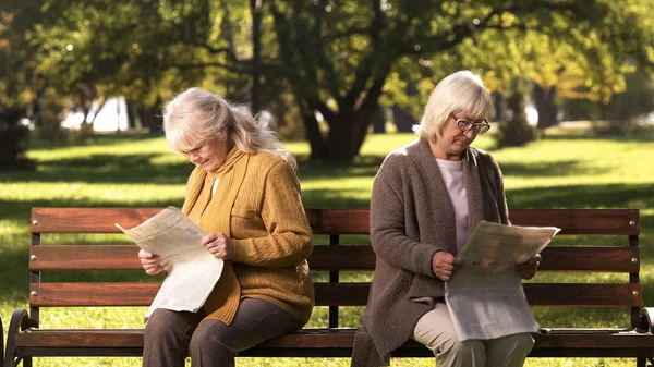 Dwóch Starszych Obrażony Koleżanki Czytanie Gazet Siedząc Ławce Parku — Zdjęcie stockowe