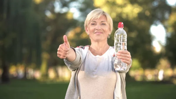 Middelaldrende Kvinne Med Flaske Vann Tomler Opp Sunn Livsstil – stockfoto