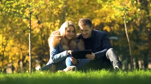 Smiling Couple Watching Photos Tablet Sitting Beautiful Autumn Park — Stock Photo, Image