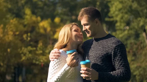 夫妇与咖啡纸杯拥抱在秋季公园 环境友好 — 图库照片