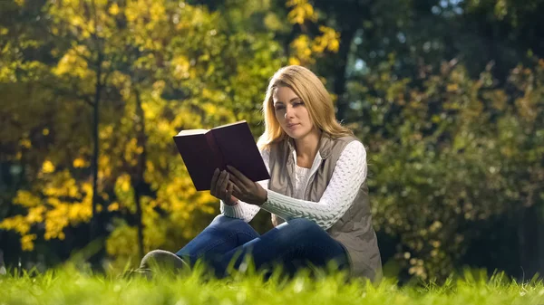 Koncentrerad Kvinna Läser Vetenskapliga Bok Höst Park Sitter Gräset — Stockfoto